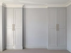 an empty room with two tall white closets