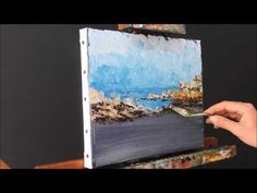 a person is painting on an easel with paint