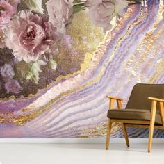 a chair sitting in front of a wall with flowers on it and an abstract background