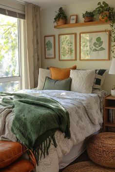 a bed sitting in a bedroom next to a window with pictures on the wall above it