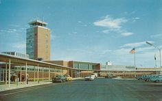 an empty parking lot in front of a tall building with a clock tower on top