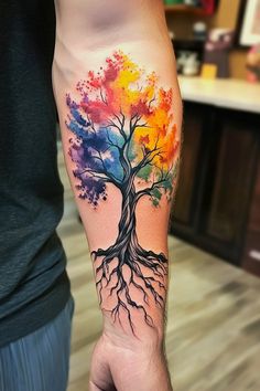 a colorful tree tattoo on the arm