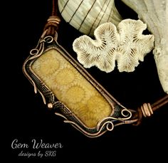 some sea shells are laying on top of a piece of wire and leather with an ornate frame