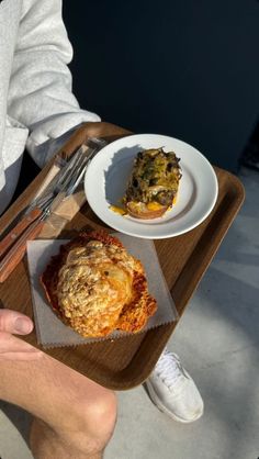 a person sitting at a table with some food in front of him on a tray