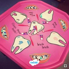 a pink table with toothbrushes and teeth on it