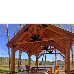 an outdoor pavilion with picnic table and chairs