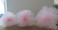 three fluffy pink pom poms sitting on top of a table