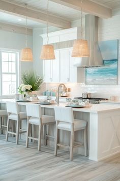 a kitchen filled with lots of white furniture