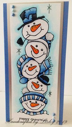 a christmas card with three snowmen in blue hats and scarfs on top of each other