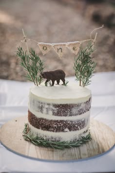 there is a cake that has a bear decoration on the top and two flags above it