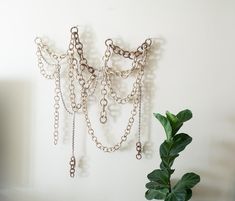 a plant is next to a wall with chains hanging on it