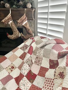 a quilted bed with christmas stockings hanging from it