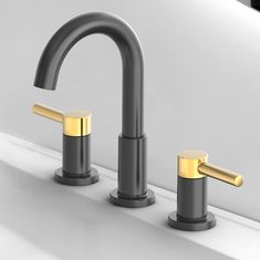 two black and gold faucets on a white countertop next to a mirror