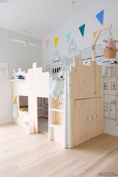 a child's room with bunk beds and toys on the floor in front of a wall drawing