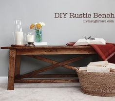 a wooden table sitting on top of a white floor next to a basket filled with books