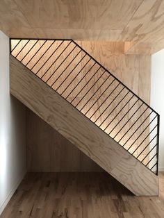 a wooden staircase with metal handrails in an empty room