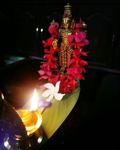 a lit candle and some flowers on a table