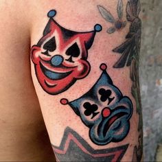 a close up of a person's arm with tattoos on it and two clown faces