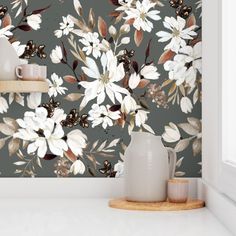 the wallpaper in this kitchen is painted with white flowers and brown leaves on a gray background