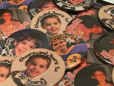 a pile of buttons with pictures of young boys on them, all in different colors and sizes