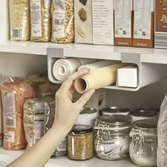 a person is holding a roll of paper in front of some food on the shelves