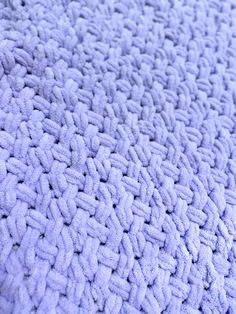 a close up view of a blue blanket that has been crocheted with yarn