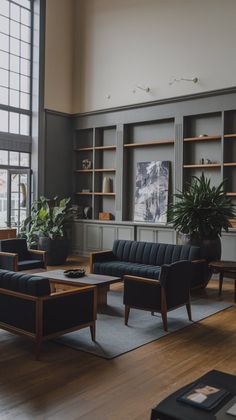 a living room filled with lots of furniture next to large windows and potted plants