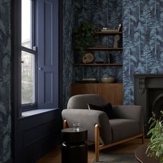 a living room filled with furniture and a fire place in front of a wallpapered wall