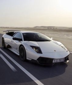 a white sports car driving down the road