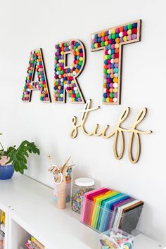 a white shelf topped with lots of colorful art and craft supplies on top of it