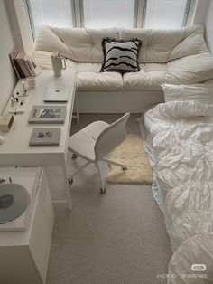 a white couch sitting next to a bed in a bedroom