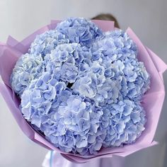 a person holding a bouquet of blue flowers