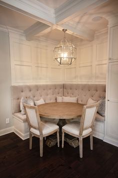 a dining room table with two chairs and a bench in front of the couches