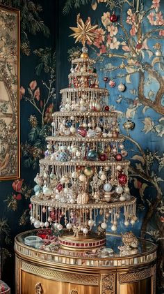 a christmas tree is sitting on top of a table in front of a blue wall