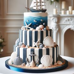 a three tiered cake decorated with seashells and a sailing ship on top