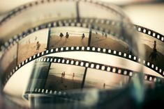 several film strips with people walking on the beach in the background and blurry image