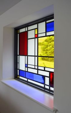 a stained glass window sitting on the side of a wall next to a wooden floor