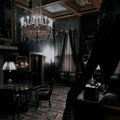 a dark room with chandelier, table and chairs