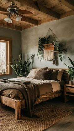 a bed sitting in a bedroom next to a window with potted plants on it