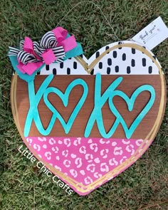 a wooden heart with the word kck painted on it in leopard print and cheetah print