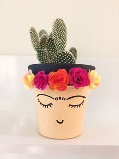 a potted plant with fake flowers on it and a face painted on the side