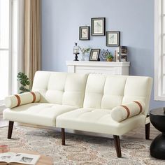 a living room with a white couch and blue walls in the corner, along with pictures on the wall