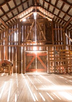 the inside of a barn with wooden floors and beams on it's walls,