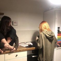 two women standing at a counter in a kitchen