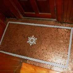 a tile floor with a cross on it in front of a door and wooden doors