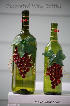 two wine bottles decorated with red berries and green leaves