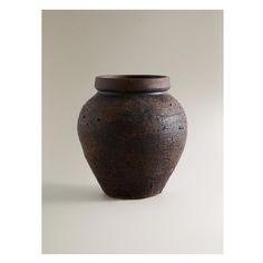 a brown vase sitting on top of a white table