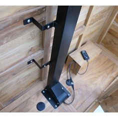 an overhead view of a wooden wall with black metal brackets and remote controls on it