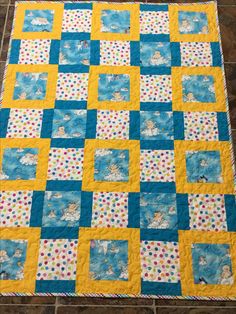 a blue and yellow quilt on the floor