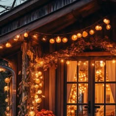 a porch decorated with lights and pumpkins